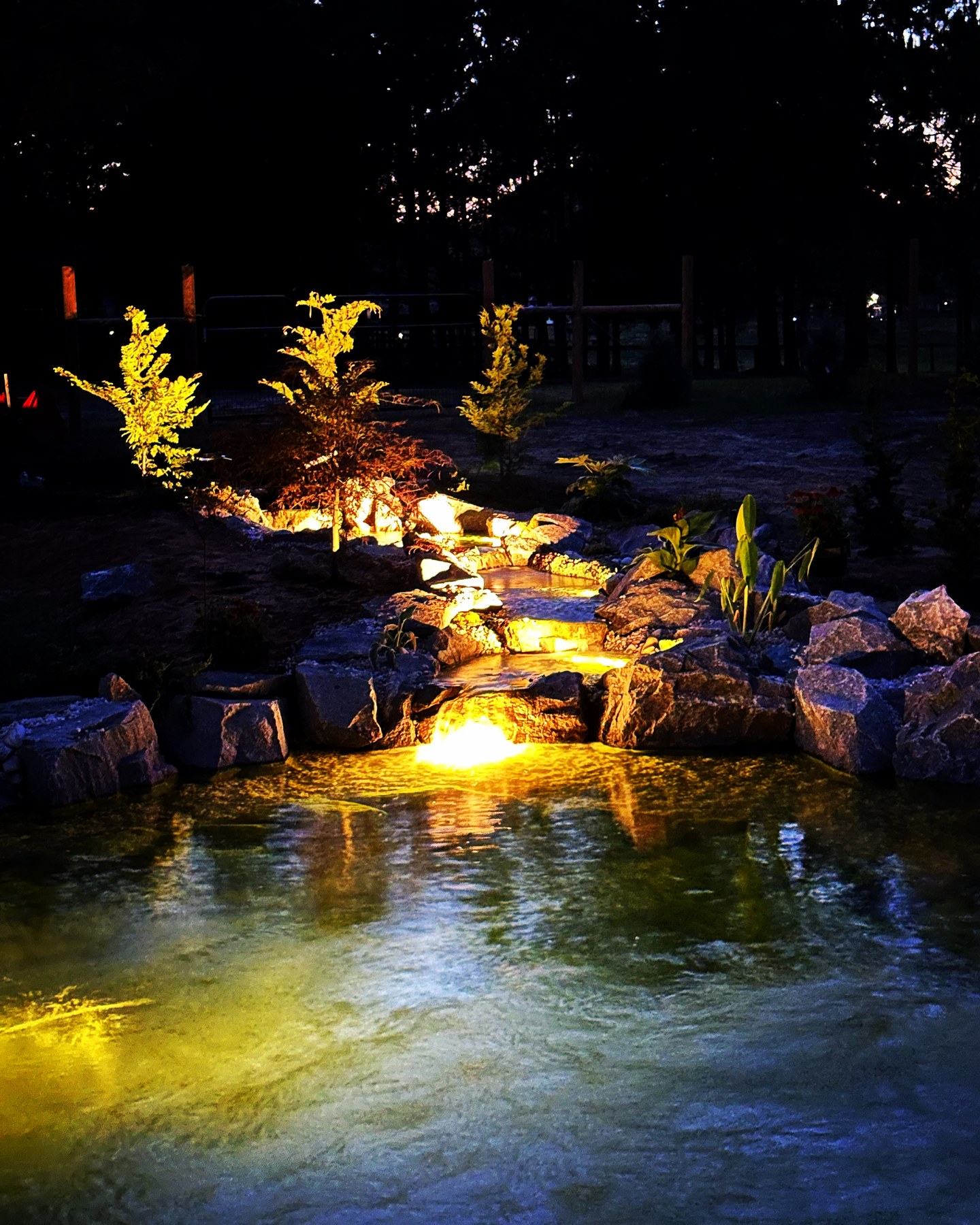 Pond and waterfall lit at night